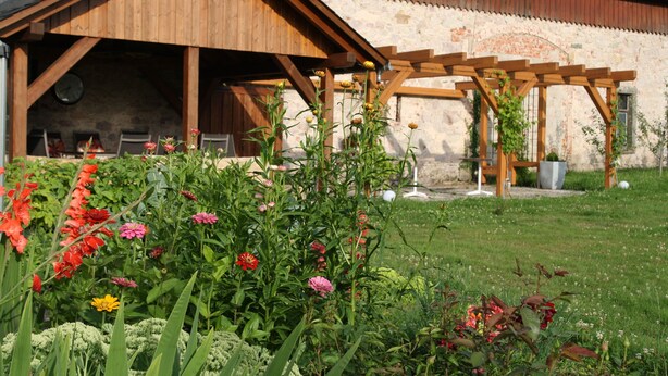 A rustic wooden building with a covered patio area. - Pension Sartor (Altenberg)
