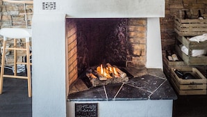 Una chimenea con un venado montado encima, una pared de piedra y un cuadro colgado.