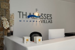 A reception desk with a sign reading "Thalasses Mykonos Villas". - Thalasses Villas (Mykonos)