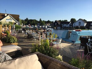 Un restaurant situé au bord de l’eau, avec une terrasse offrant une vue sur un port de plaisance.