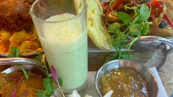 A variety of dishes including fried chicken, a green smoothie, and a salad with sprouts.
