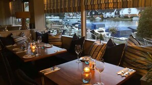 A restaurant with a view of boats on a canal. - Hotel Wroxham (Norwich)