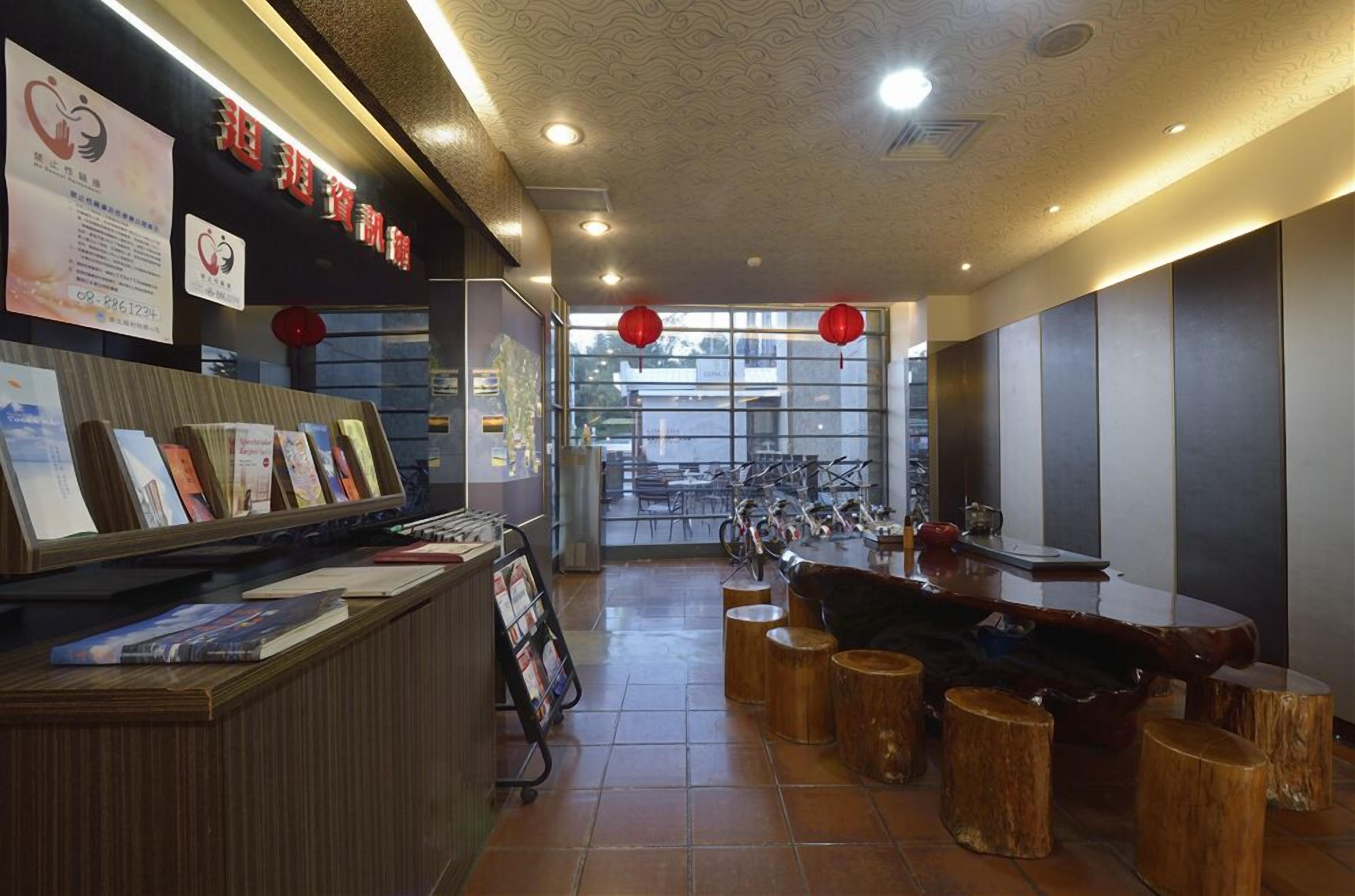 A restaurant with a wooden counter, red lanterns, and a view of bicycles outside.