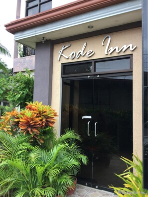The entrance to Kode Inn with a glass door and a sign above. - Kode Inn (Tagbilaran)
