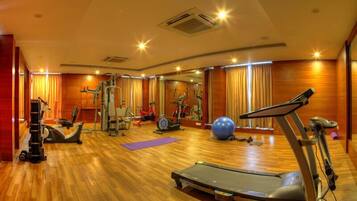 A gym with exercise equipment, a treadmill, and a large exercise ball.