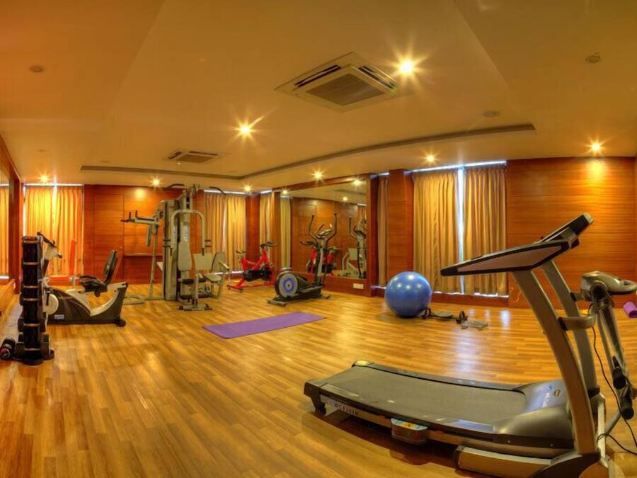 Une salle de sport équipée de matériel d’exercice, d’un tapis de course et d’un grand ballon de gymnastique.