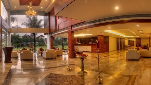 A spacious lobby with a reception desk, seating area, and a view of the outdoors. - Hotel Le Ruchi the Prince (Mysore)