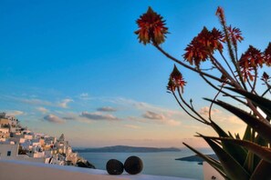 A coastal town with white buildings, a clear sky, and a view of the sea. - Fira white residence (Santorini)
