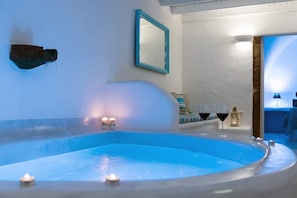 Zona de spa con hidromasaje, velas y vistas al mar.