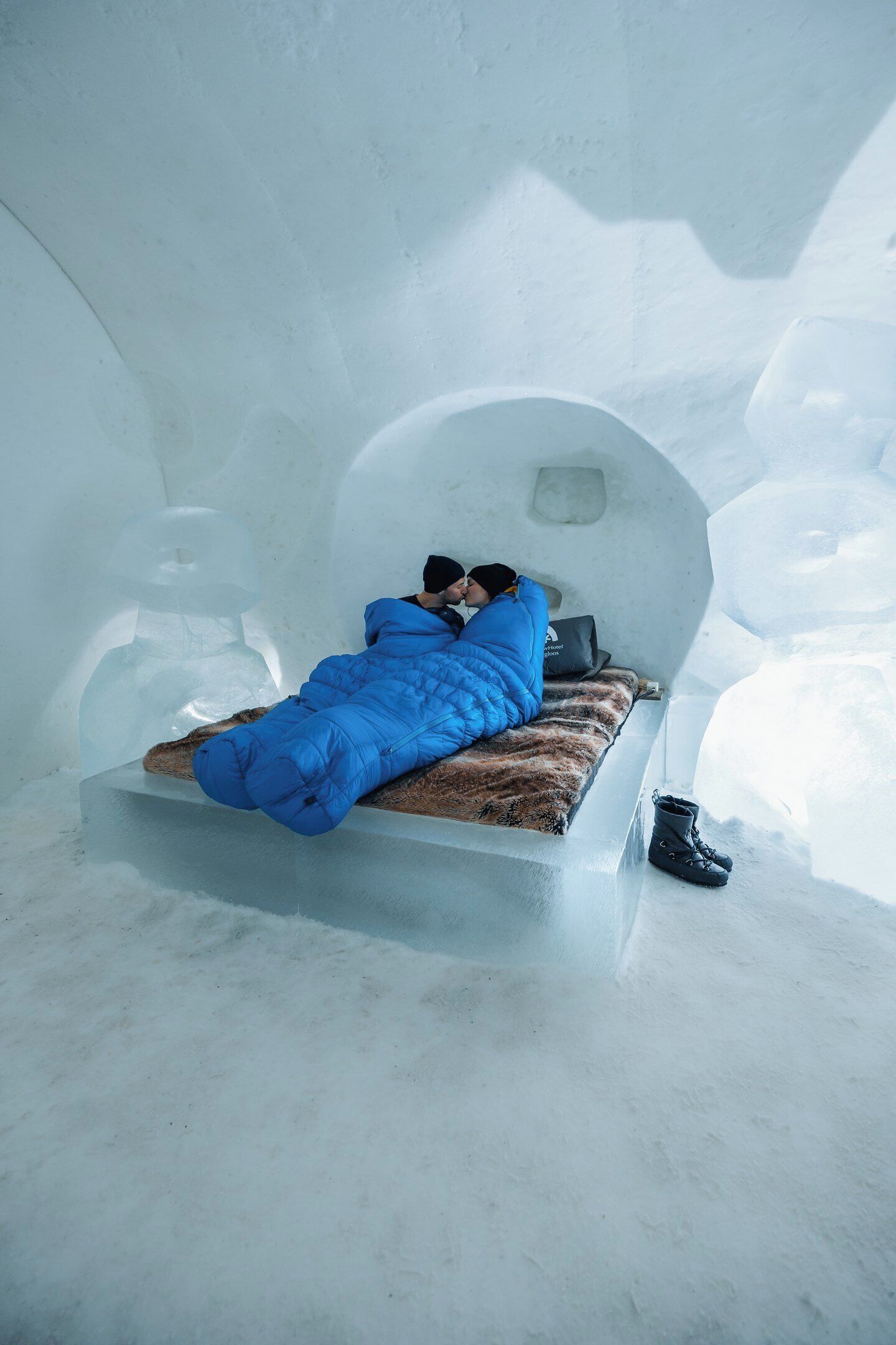 A cozy igloo bedroom with a bed, a pillow, and a boot.