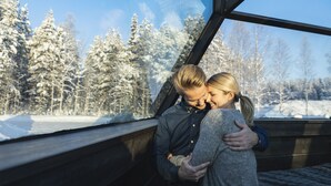 A couple embracing in a cabin with a view of snow-covered trees. - Arctic SnowHotel & Glass Igloos (Rovaniemi)