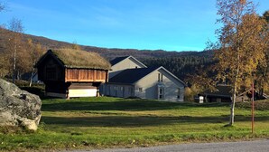 A house with a large garage, a barn, and a grassy yard. - Bykle Hotell  (Bykle)