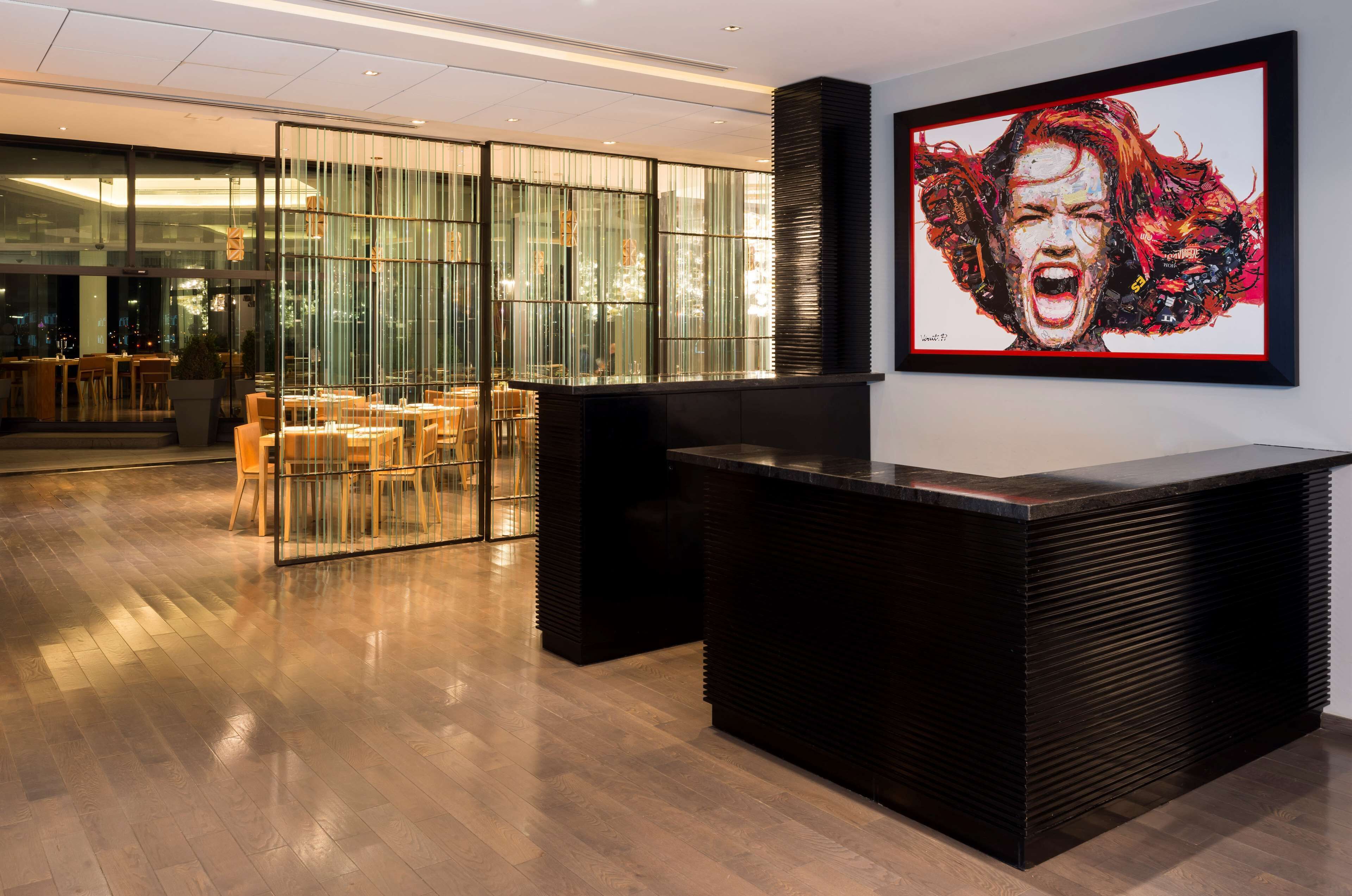 A reception area with a modern design, featuring a wooden reception desk and a glass partition.