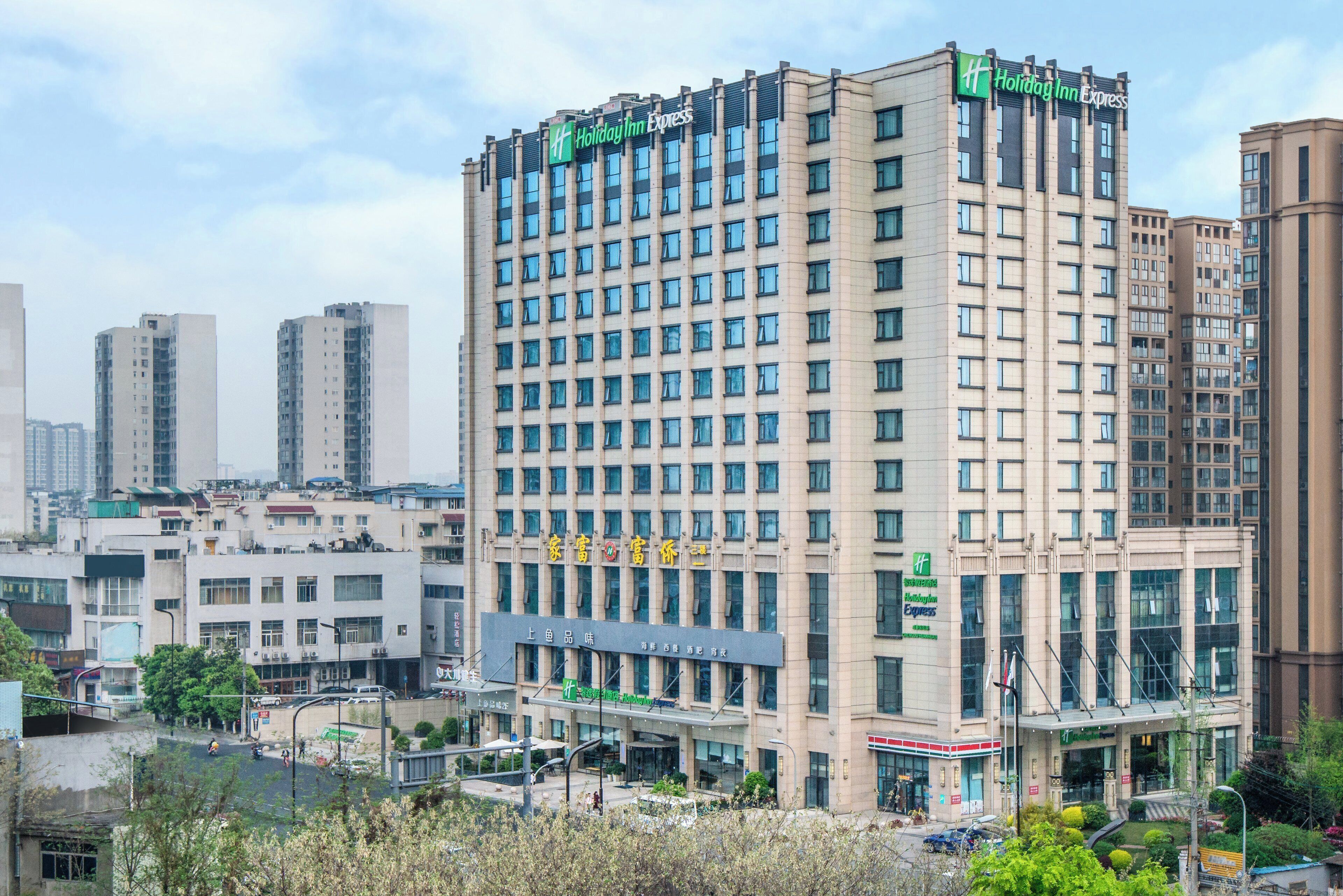 A multi-story building with a Holiday Inn Express sign, featuring a grid of windows and a flat facade.
