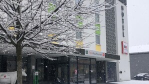 Un hôtel doté d’une façade moderne, de grandes fenêtres et d’une entrée bien visible.
