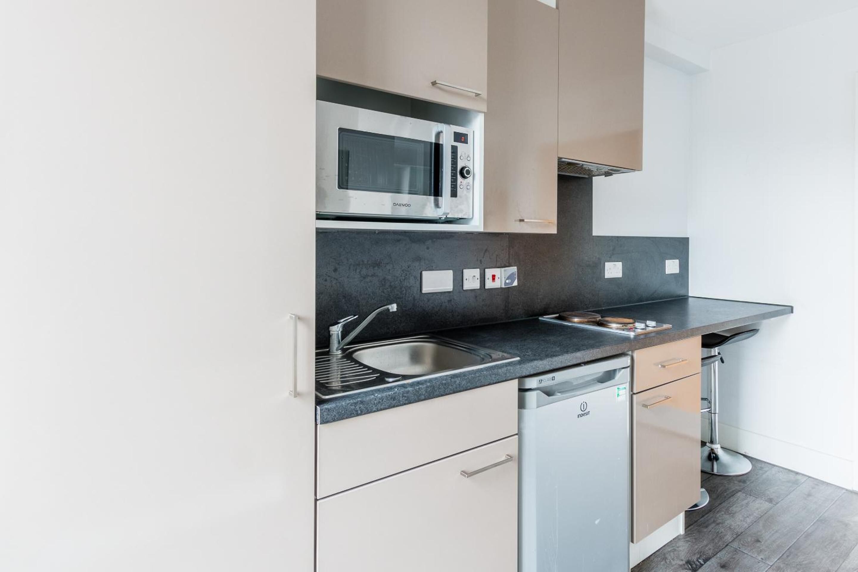 A modern kitchen with a built-in microwave, a sink, and a dishwasher.
