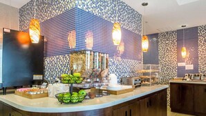 A breakfast bar with a tiled backsplash, a fruit display, and a coffee station. - MainStay Suites Midland (Midland)