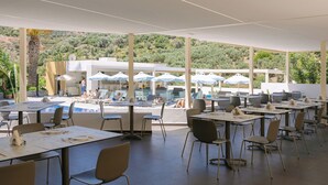 A restaurant with outdoor seating, a pool, and a view of the hills. - Xidas Garden  (Mylopotamos)