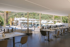A restaurant with outdoor seating, a pool, and a view of the hills. - Xidas Garden  (Mylopotamos)