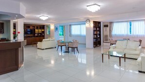 A modern living room with a kitchen area, a dining table with chairs, and a sofa. - Xidas Garden  (Mylopotamos)
