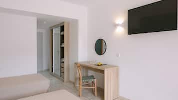 A modern room with a bed, a desk with a chair, a TV, and a wardrobe.