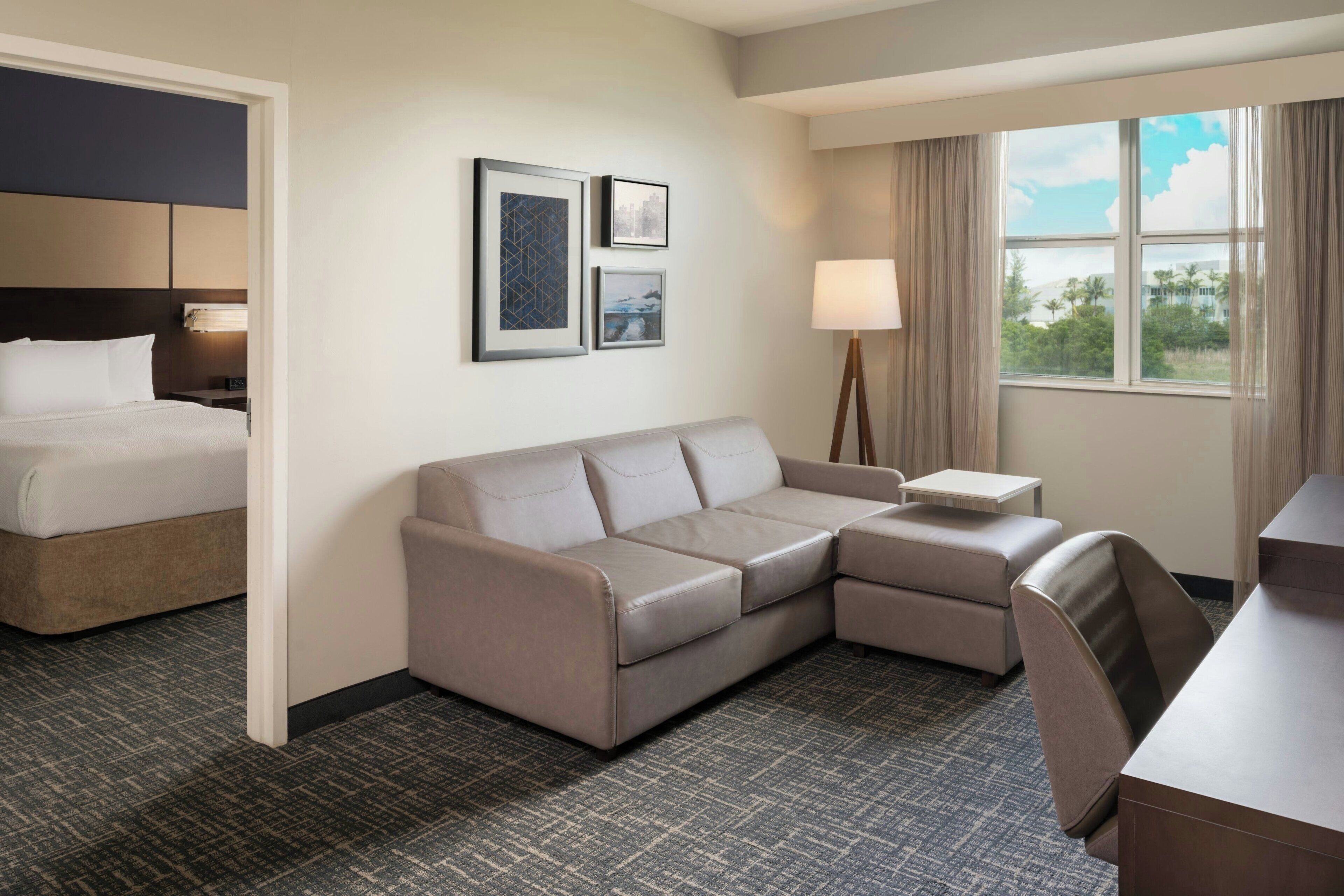 Ein Hotelzimmer mit Bett, Sofa, Schreibtisch und Lampe.