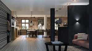 Une cuisine moderne avec un coin repas, un sol à motifs en noir et blanc et un canapé agrémenté de coussins à motifs.