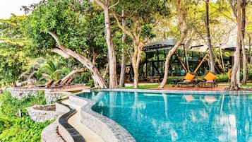 Alberca al aire libre, sombrillas en la alberca y camastros