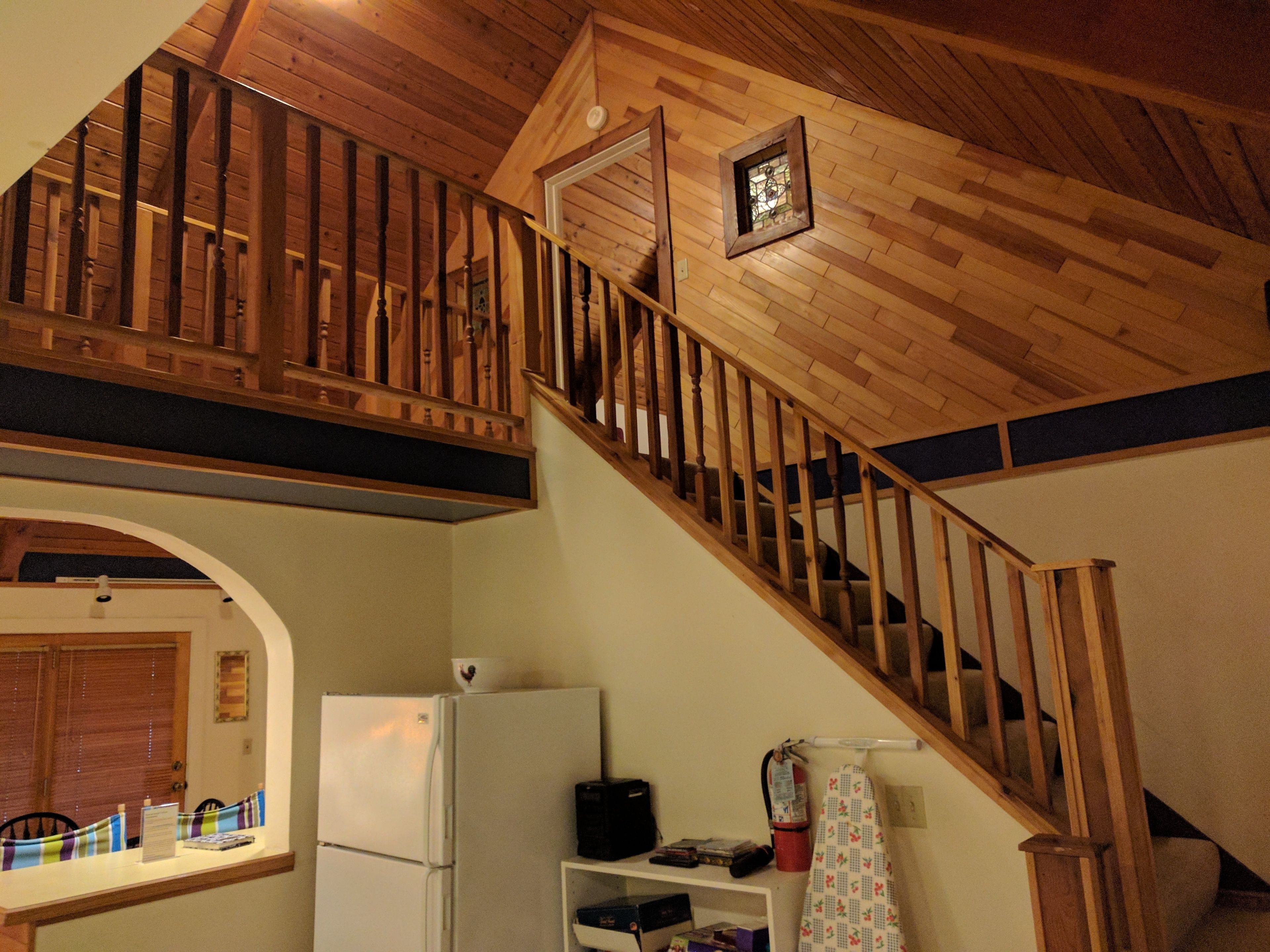 Una escalera de madera con barandilla que conduce a un nivel superior.