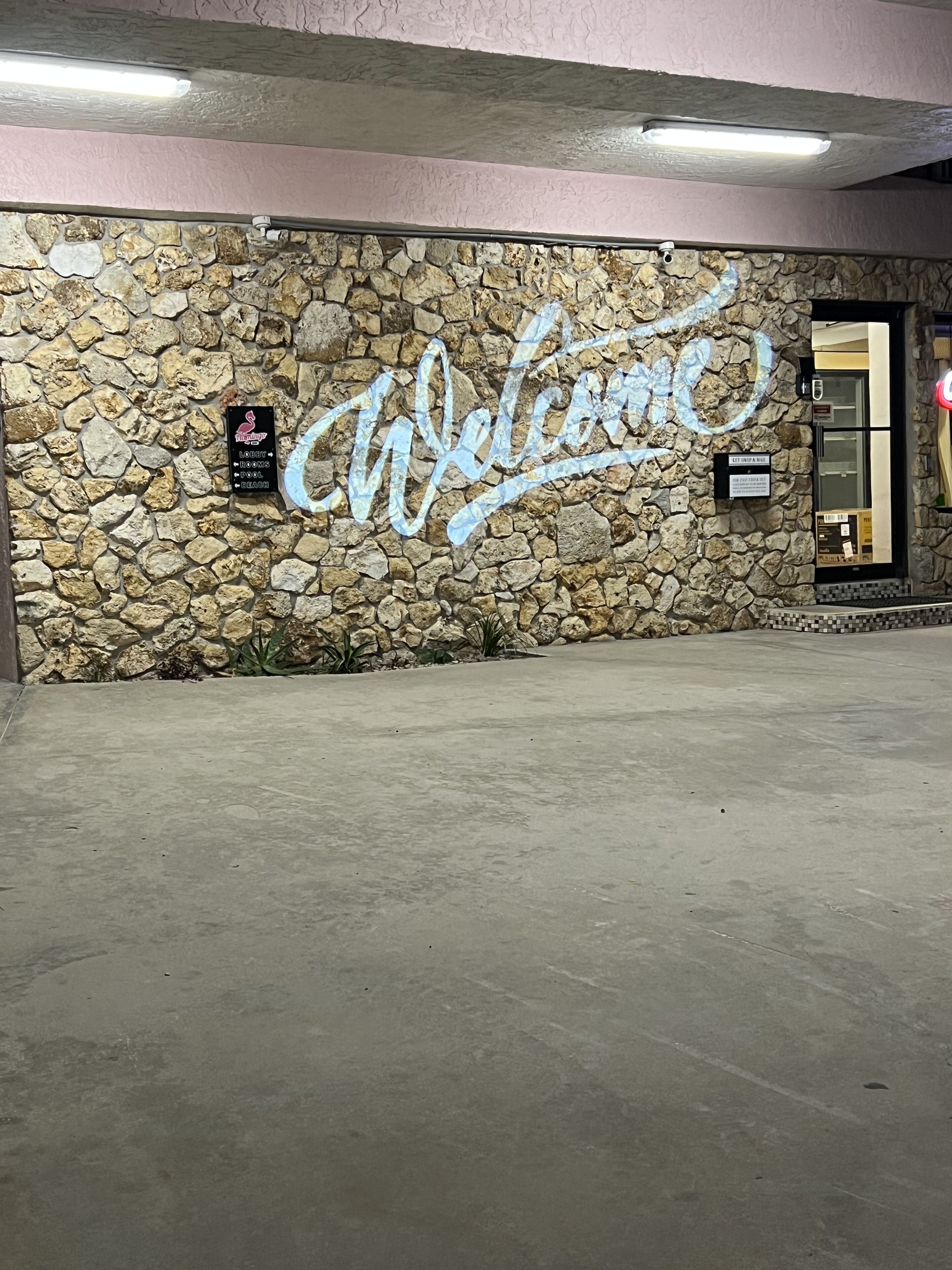 Un mur de pierre avec une pancarte indiquant « Bienvenue » et une autre indiquant un centre de remise en forme.