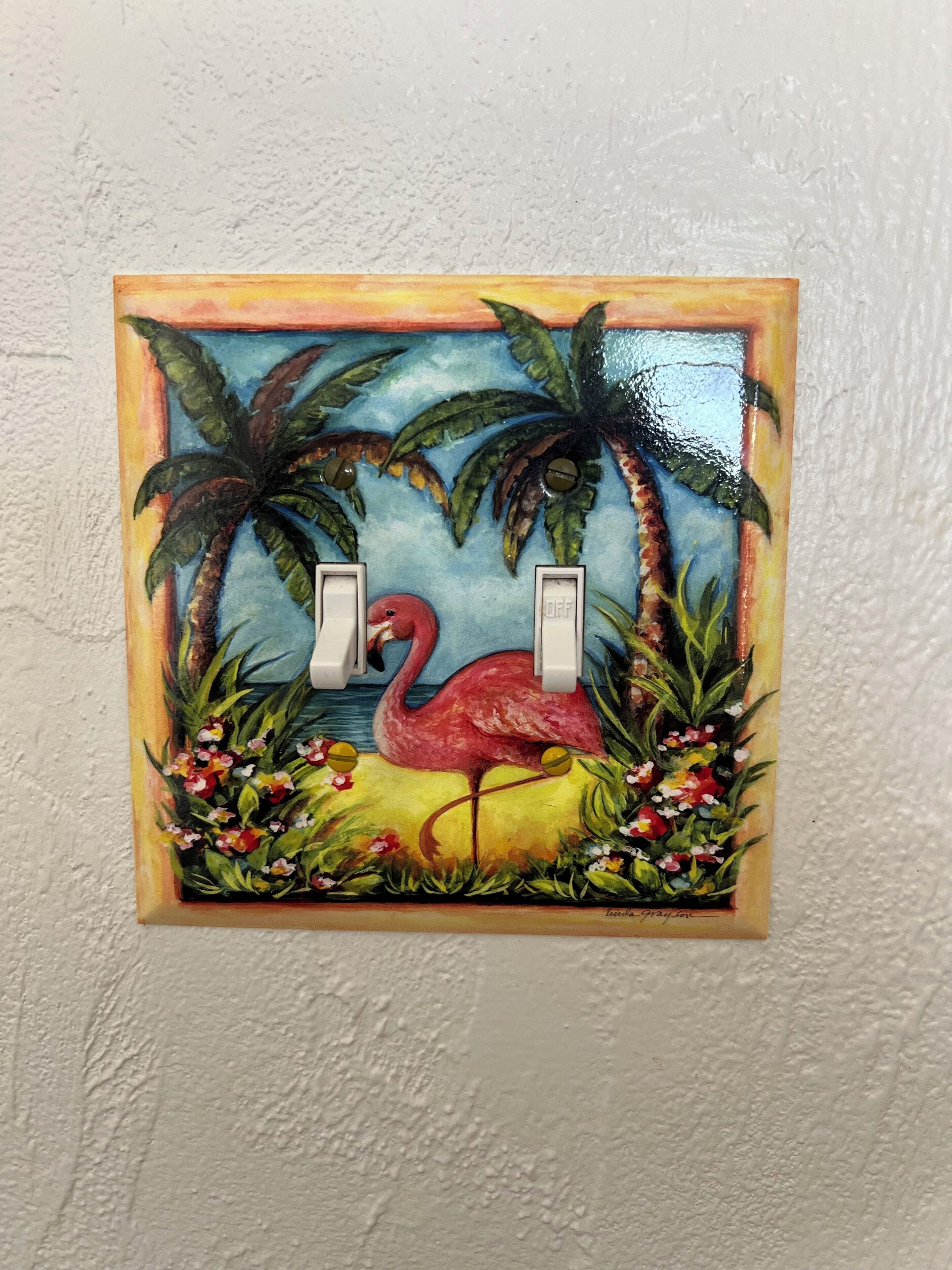 A painting of a pink flamingo with two switches, surrounded by tropical plants and flowers.