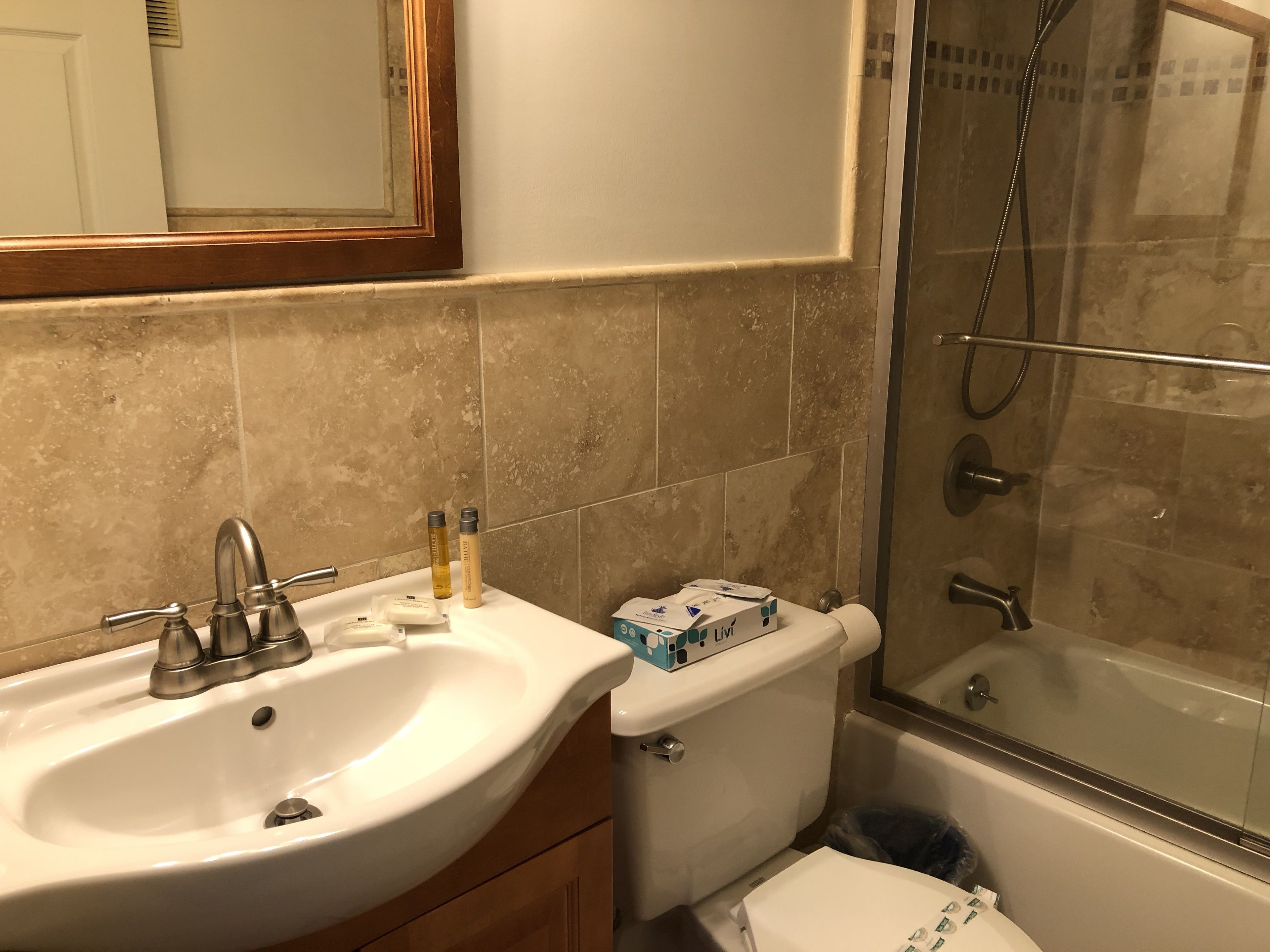 A bathroom with a white sink, a toilet, and a glass-enclosed shower.