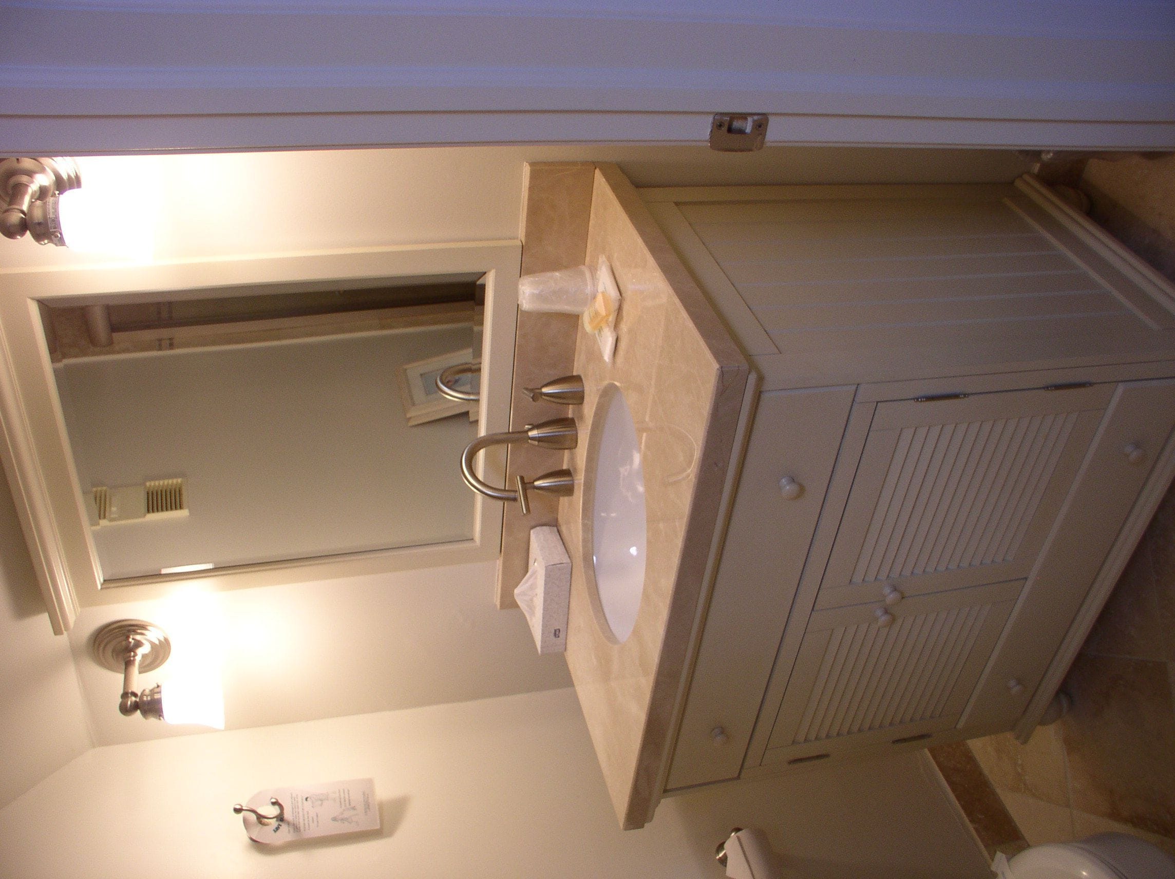 A bathroom with a sink, mirror, towel rack, and a toilet.
