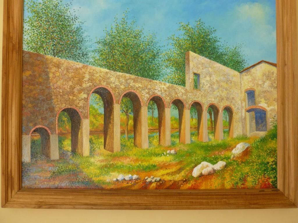 A painting of an ancient stone structure with arches, surrounded by greenery and trees.