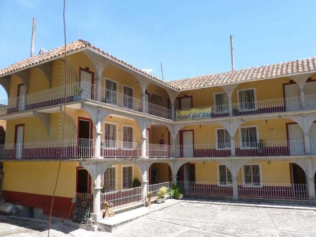 A multi-story hotel with a yellow facade, multiple balconies, and a courtyard.