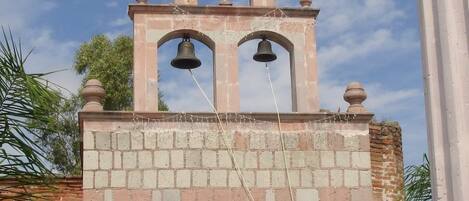 A church with a bell tower, a cross on top, and a sign with text.