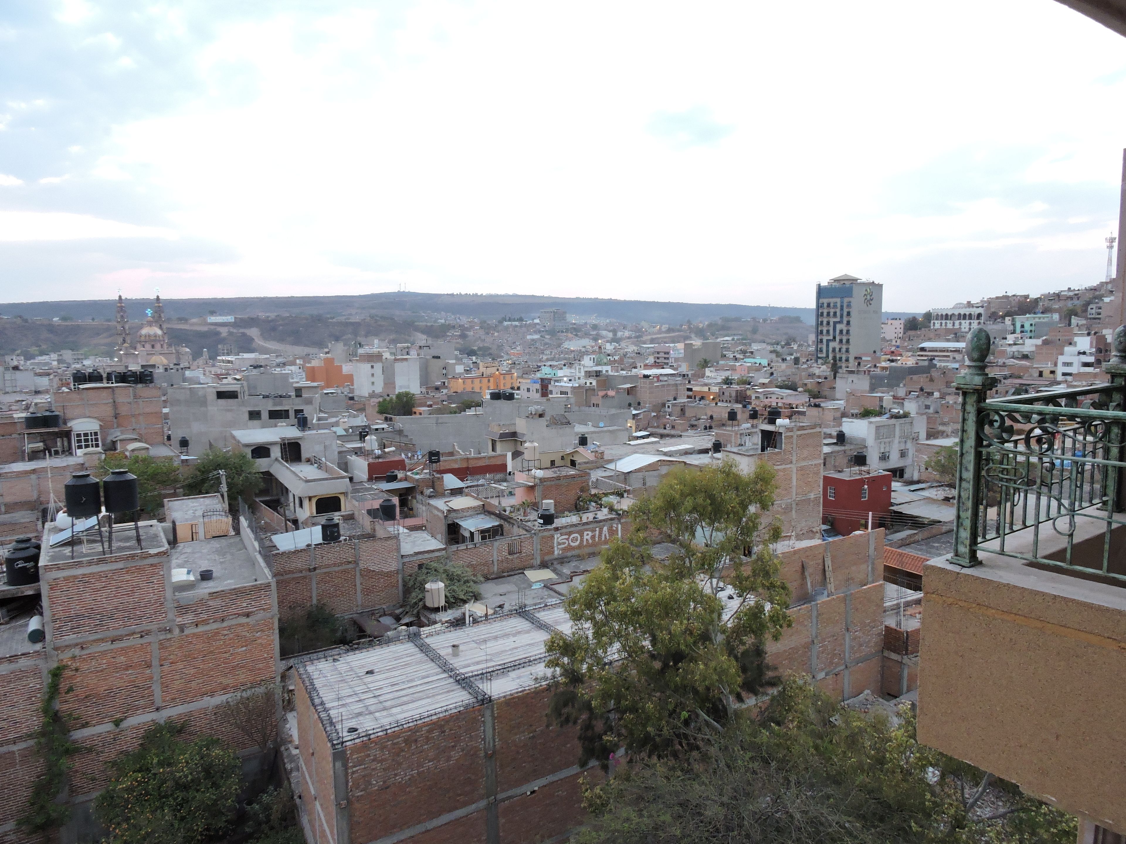 A cityscape with a mix of residential and commercial buildings, including a prominent mosque with a dome and minarets.