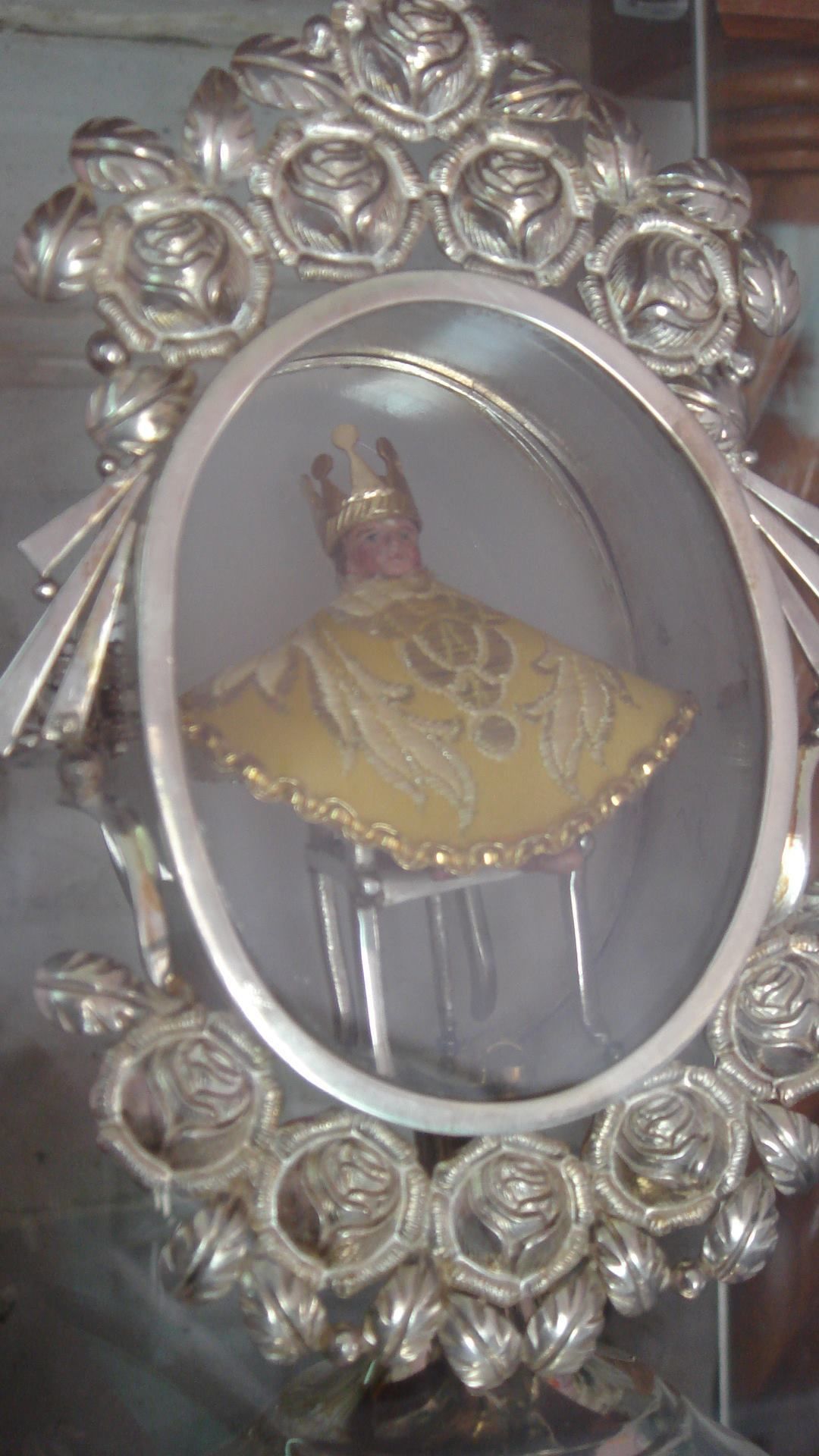 Un miroir doté d’un cadre argenté orné de motifs floraux.