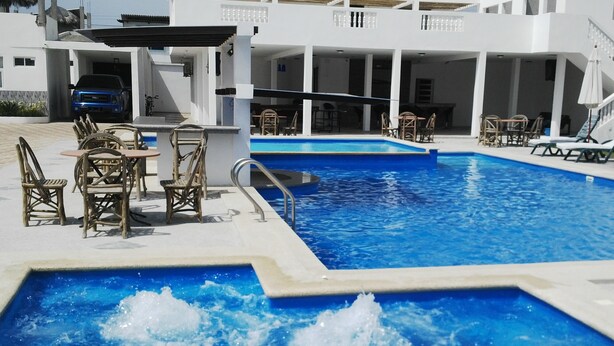 A pool area with multiple seating arrangements and a clear blue pool. - Terramar Hoteles  (Crucita)