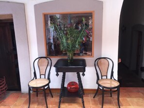 A room with two wicker chairs, a black table, and a potted plant. - Casa del Pingorongo (Zacatecas)