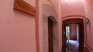 A corridor with a sign reading 'MADRILENA' and an arched doorway. - Casa del Pingorongo (Zacatecas)