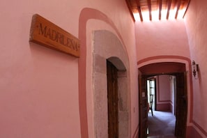 A corridor with a sign reading 'MADRILENA' and an arched doorway. - Casa del Pingorongo (Zacatecas)