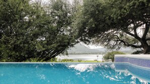 A swimming pool with a view of a lake and mountains in the background. - Quinta del Lago (Querétaro)