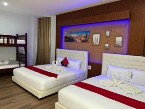 A hotel room with two beds, a bunk bed, and a wall with framed pictures. - River Grand Hotel Hat Yai (Hat Yai)
