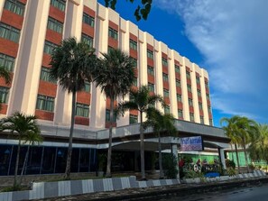 A multi-story hotel with a flat facade, palm trees in front, and a sign indicating it's the RiverGrand Hotel. - River Grand Hotel Hat Yai (Hat Yai)