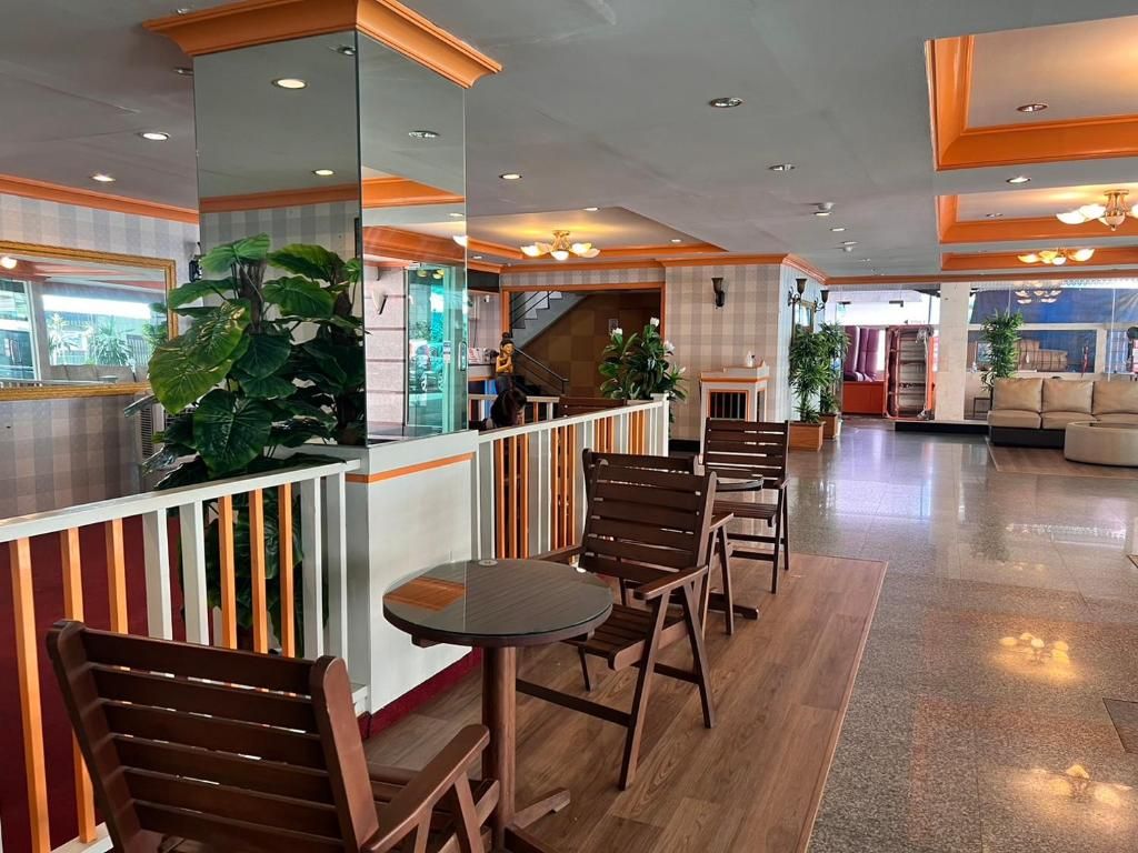 A hotel lobby with a reception desk, seating area, and a staircase leading to upper floors.