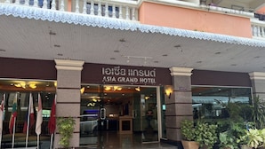 The exterior of Asia Grand Hotel with a covered entrance, glass doors, and potted plants. - Asia Grand Hotel Hat Yai (Hat Yai)