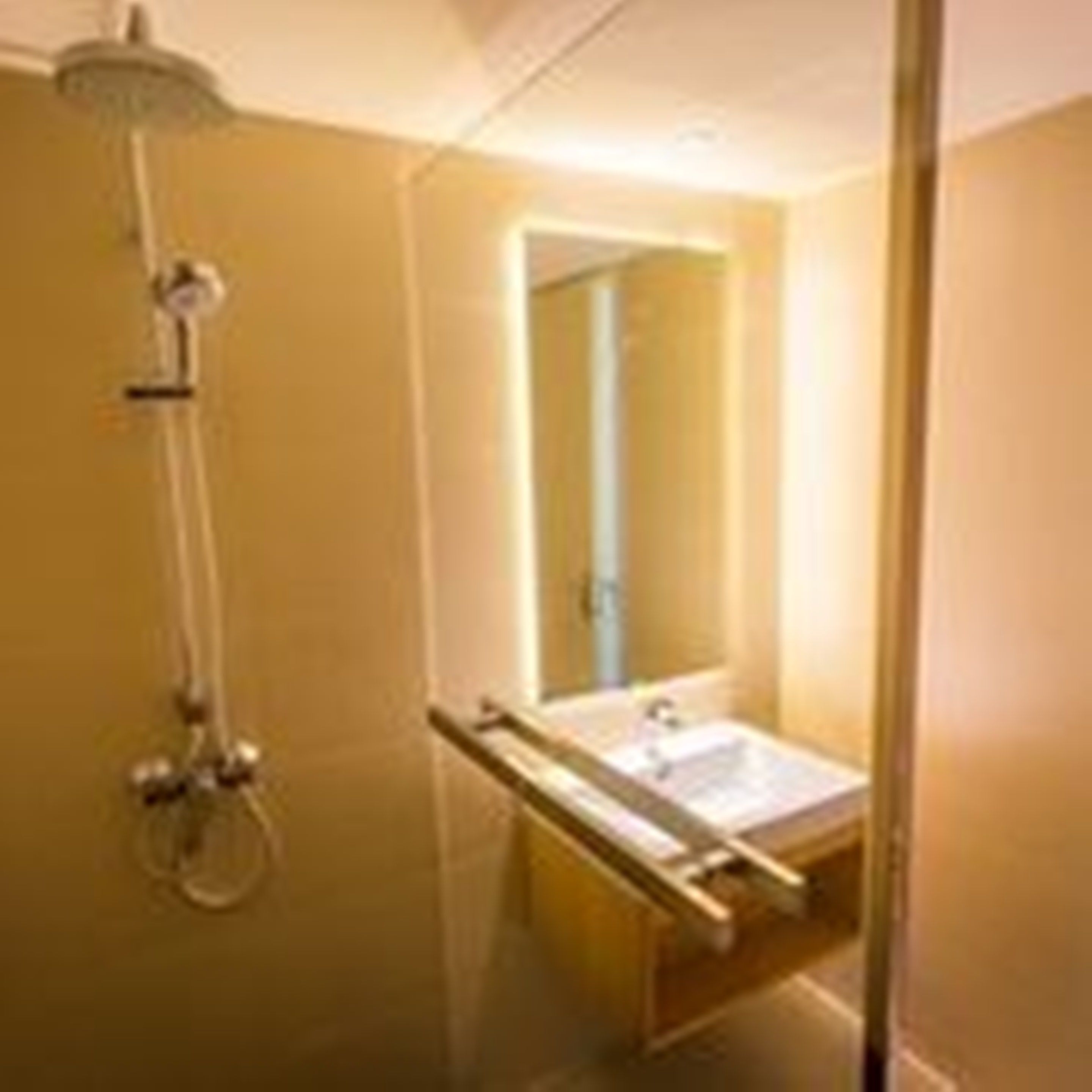 Une salle de bain moderne avec une douche à parois de verre, un lavabo et un miroir.