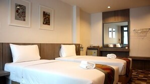 A hotel room with two beds, a large mirror, and artwork on the wall. - P'Residence (Hat Yai)