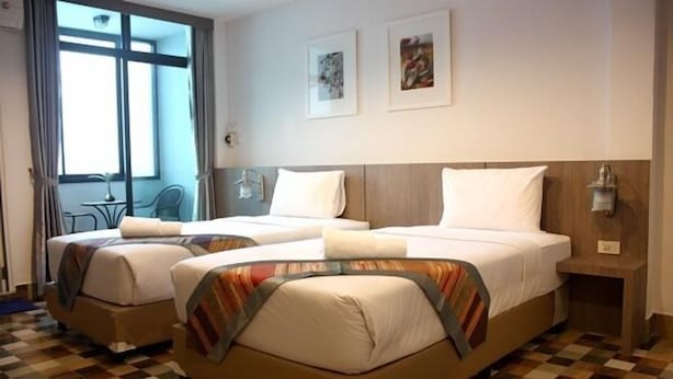 A hotel room with two beds, checkered floor, large window with curtains, and artwork on the wall. - P'Residence (Hat Yai)